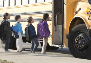 A line of students getting on the school bus.