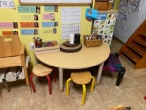 Semicircle table next to a wall with 2 small stools